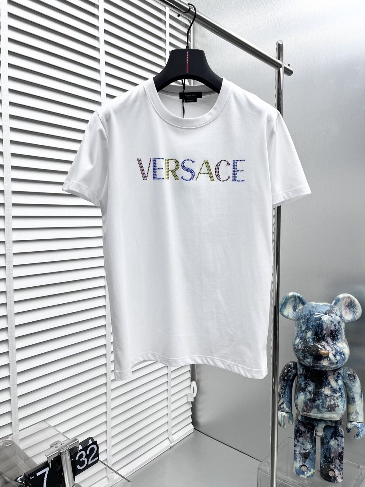 ⁦تصميم جديد من فيرساتشي بأكمام قصيرة، مطبوع عليه شعار بحروف ماسية بلون الماس، بطباعة حرارية.⁩ - الصورة ⁦1⁩