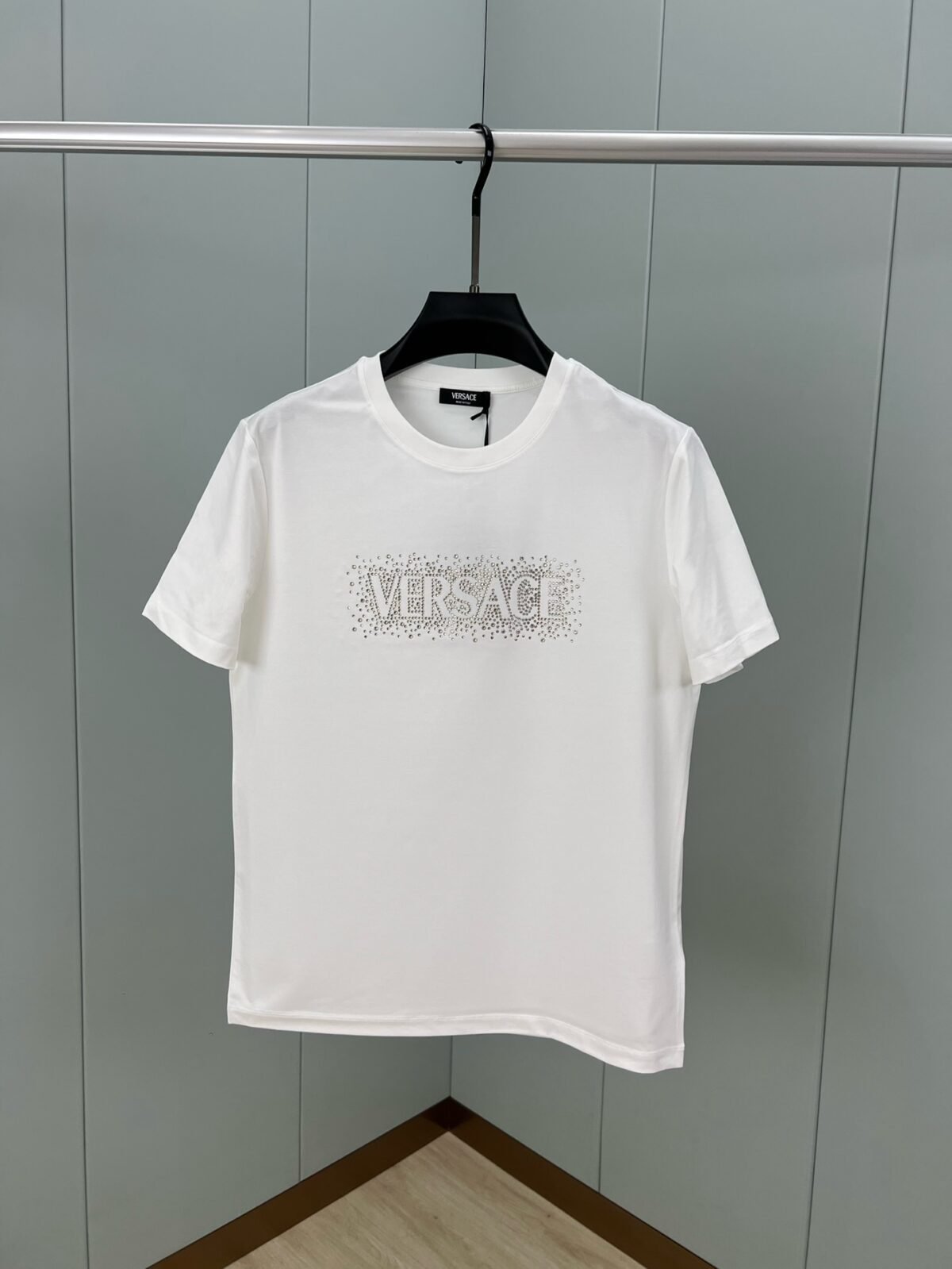 ⁦تيشيرت فيرساتشي الجديد بأكمام قصيرة ومزين بشعار العلامة التجارية، مزين بمسامير كريستالية.⁩ - الصورة ⁦1⁩