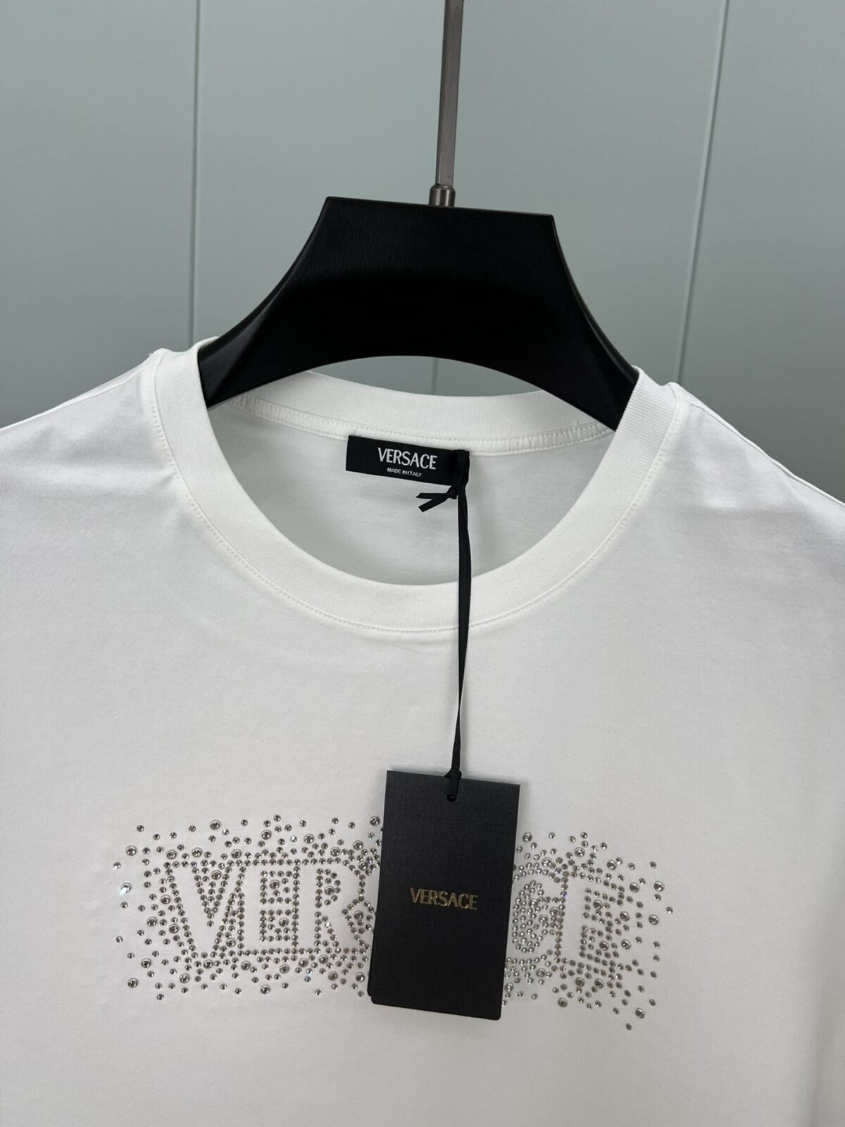 ⁦تيشيرت فيرساتشي الجديد بأكمام قصيرة ومزين بشعار العلامة التجارية، مزين بمسامير كريستالية.⁩ - الصورة ⁦5⁩