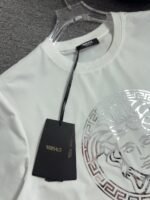 ⁦تيشيرت فيرساتشي الجديد بياقة دائرية وأكمام قصيرة، يحمل شعار العلامة التجارية الكلاسيكي على المقدمة.⁩ - الصورة ⁦6⁩